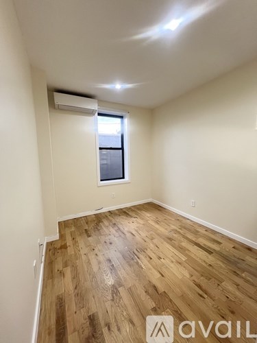 A room with wooden flooring and a window.