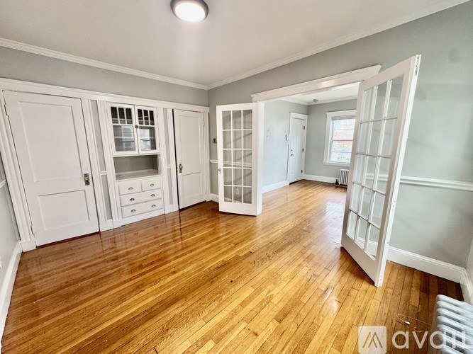 A room with wooden floors and white cabinetry.
