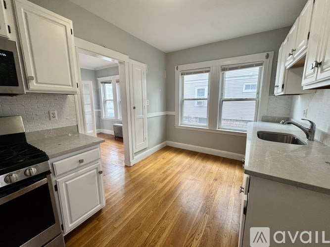 A kitchen with white cabinets and a black stove top oven.