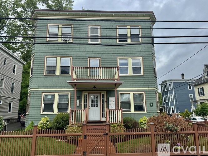 A green house with a white door and windows.