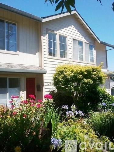 A house with a red door and a garden in front.