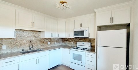 A kitchen with white cabinets and appliances.