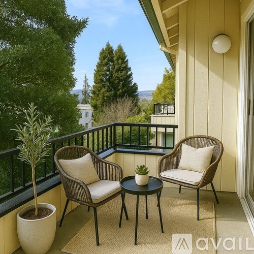 A balcony with two chairs and a table with a plant on it.