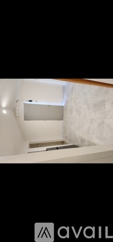 A room with a white wall and a wooden beam on the ceiling.