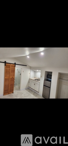 A kitchen with a wooden door and white cabinets.