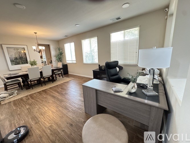 A well-lit room with a desk and chairs.