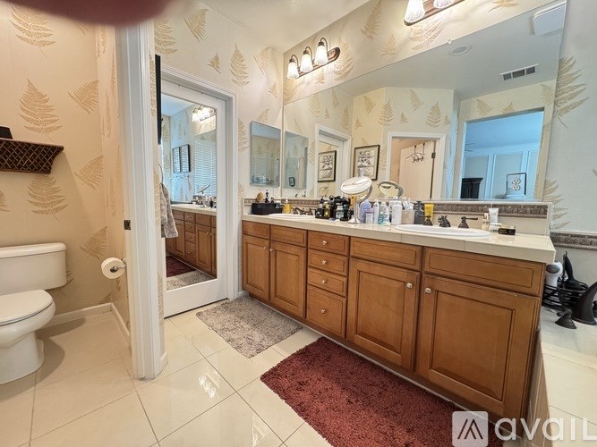 A bathroom with a white toilet and a wooden vanity.