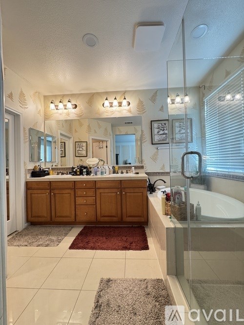 A bathroom with a vanity, a mirror, and a rug.