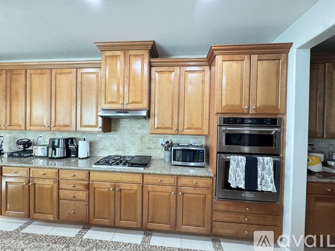 A kitchen with wooden cabinets and a black stove top.