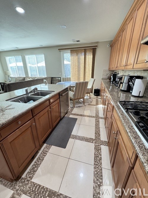 A kitchen with brown cabinets and a marble countertop.