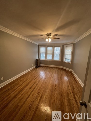 A room with wooden flooring and a ceiling fan.