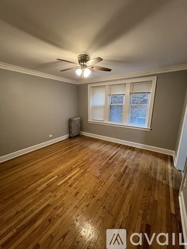 A room with wooden floors and a ceiling fan.