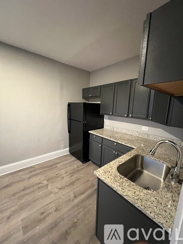 A kitchen with a sink and a refrigerator.
