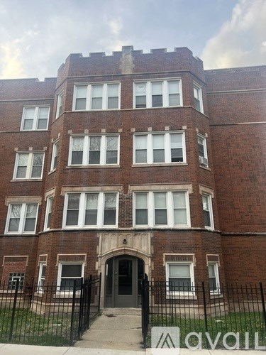 A brick building with a black gate in front.