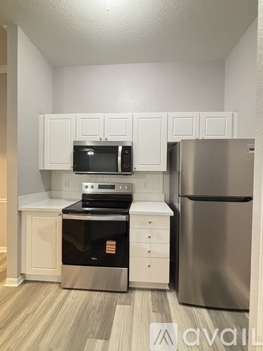 A kitchen with white cabinets and stainless steel appliances.