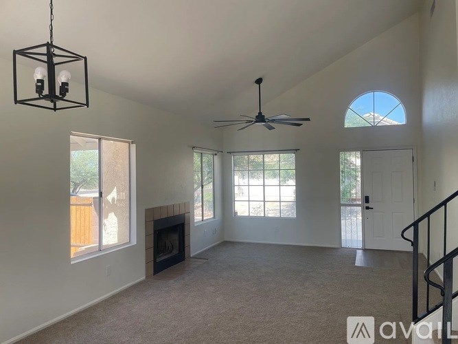 A living room with a fireplace and a ceiling fan.
