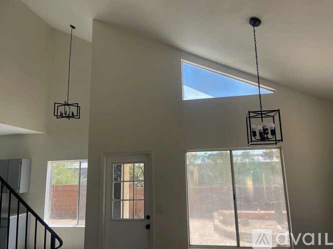 A room with a door, a window, and a hanging light fixture.