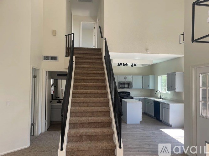 A staircase with a carpeted runner leads up to a second floor.