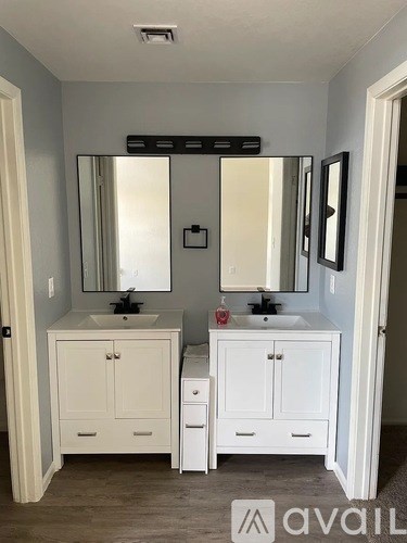 A bathroom with two sinks and a large mirror.