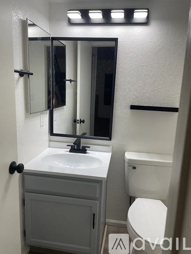 A white bathroom with a sink, toilet and mirror.