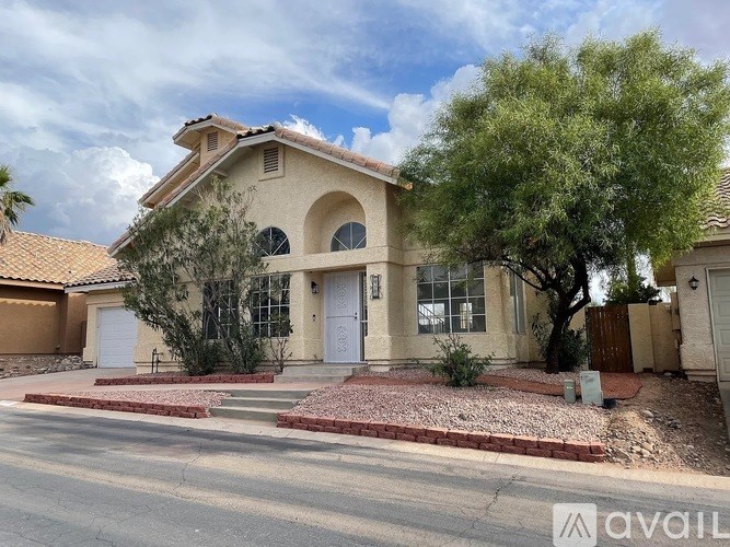 A house with a white door and a tree in front.