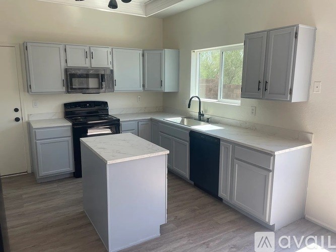 A kitchen with white cabinets and a black stove top oven.