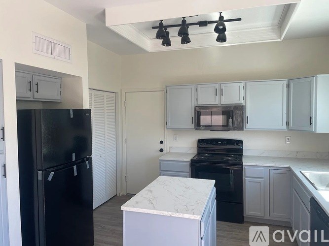 A kitchen with black appliances and white cabinets.