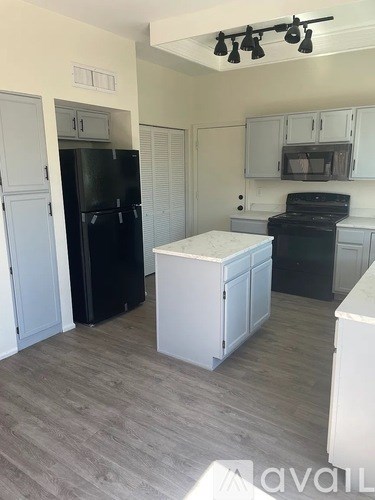 A kitchen with black appliances and white cabinets.
