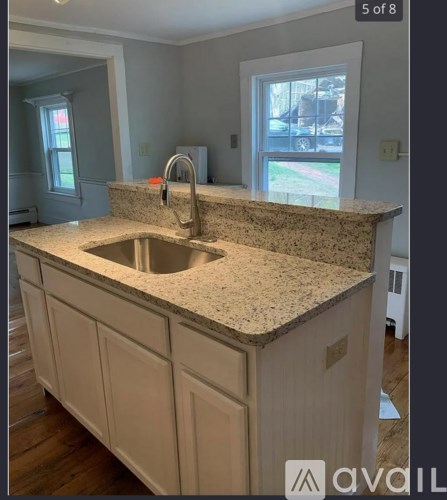 A kitchen with a granite countertop and a window.