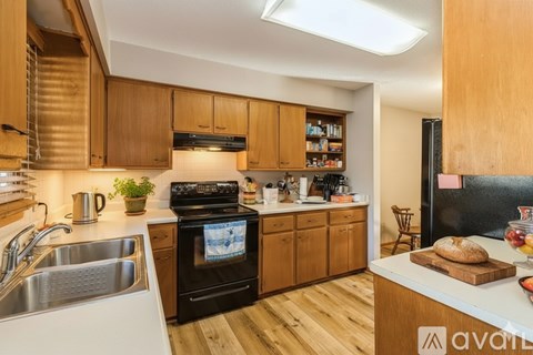 A kitchen with wooden cabinets and a black stove top oven.