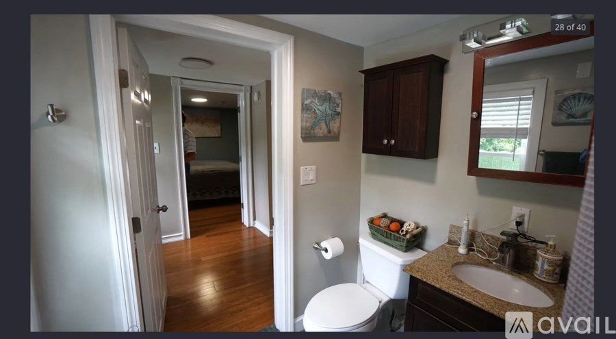 A bathroom with a toilet, sink, and mirror.