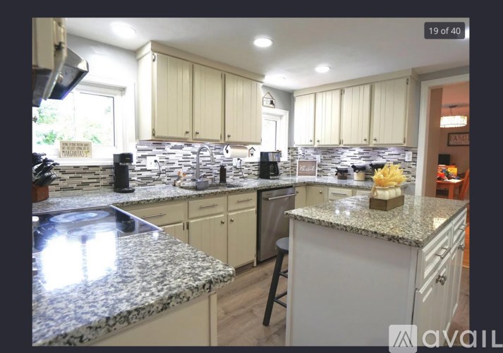 A kitchen with granite countertops and white cabinets.