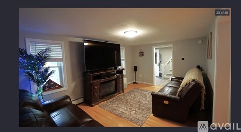 A living room with a leather couch and a television.
