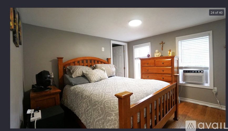 A bedroom with a bed, nightstand, and window.