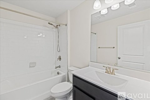 A white bathroom with a toilet, sink, and shower.