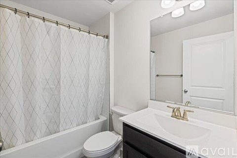 A white bathroom with a toilet, sink, and shower.