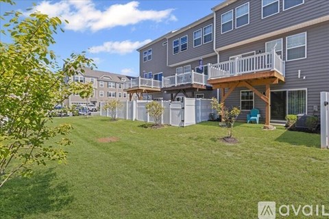 A large grassy area in front of a building with a balcony.