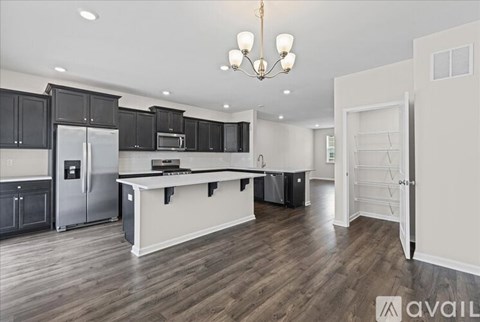 A modern kitchen with a wooden floor and a large island.