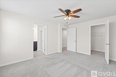A room with a ceiling fan and carpeted floor.