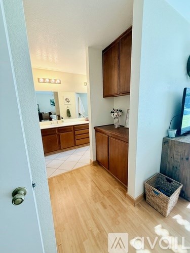A hallway with a wooden floor and a door on the left.