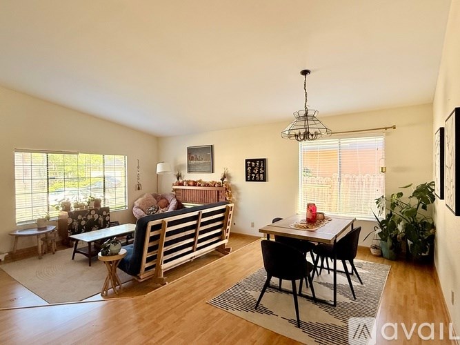A living room with a couch, chairs, and a dining table.