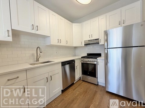 A kitchen with white cabinets and a stainless steel refrigerator.