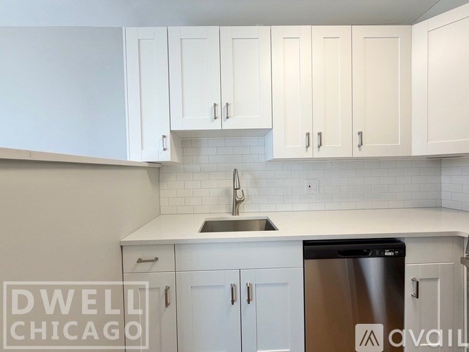 A kitchen with white cabinets and a stainless steel dishwasher.