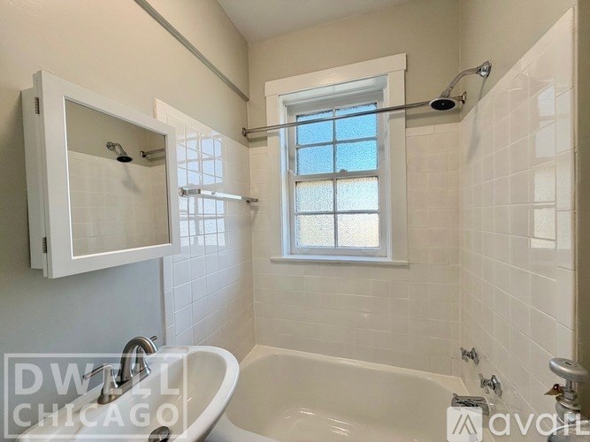 A white bathroom with a tub, shower, and window.