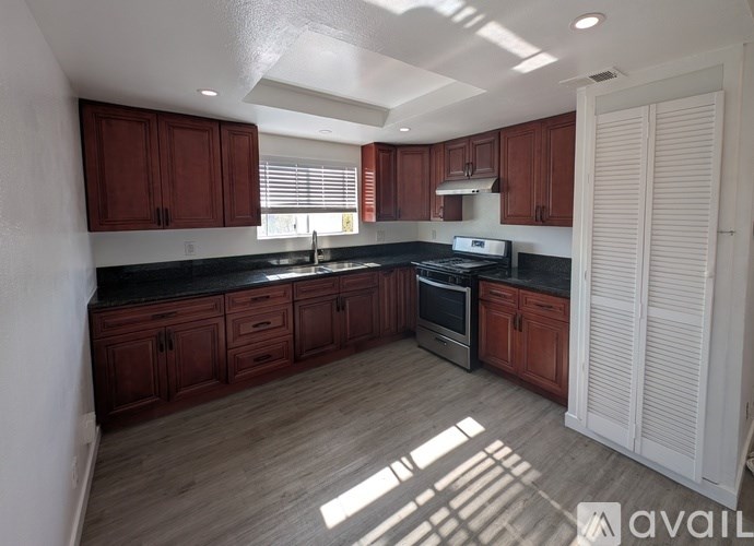 A kitchen with wooden cabinets and black countertops is available.
