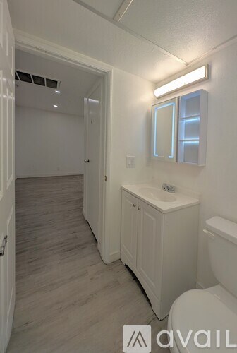 A bathroom with a toilet, sink, and mirror.