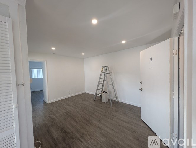 A room with a ladder and a white wall with a number 9 on it.