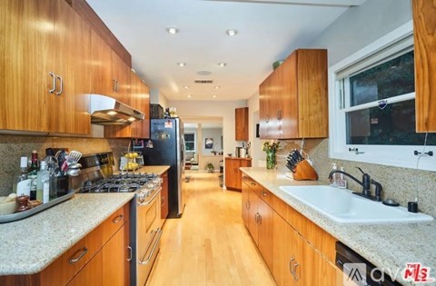 A kitchen with wooden cabinets and granite countertops.
