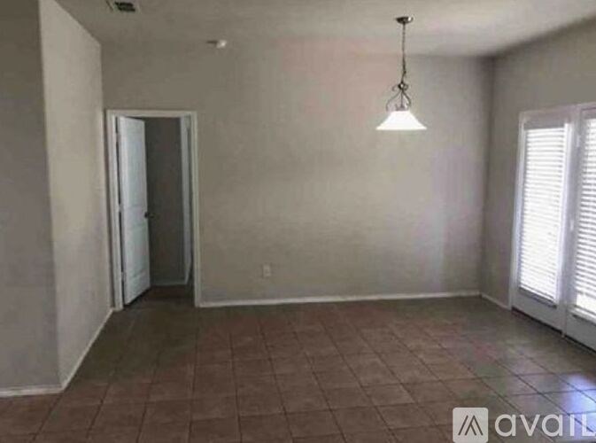 A room with tiled flooring and a hanging light fixture.