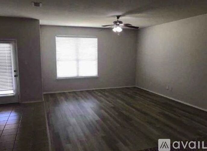 A room with wooden flooring and a ceiling fan.